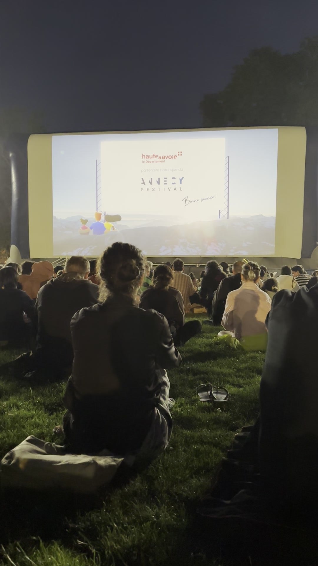 Open-air screening at the Annecy International Animation Film Festival, the audience gathered in front of the screen at dusk.